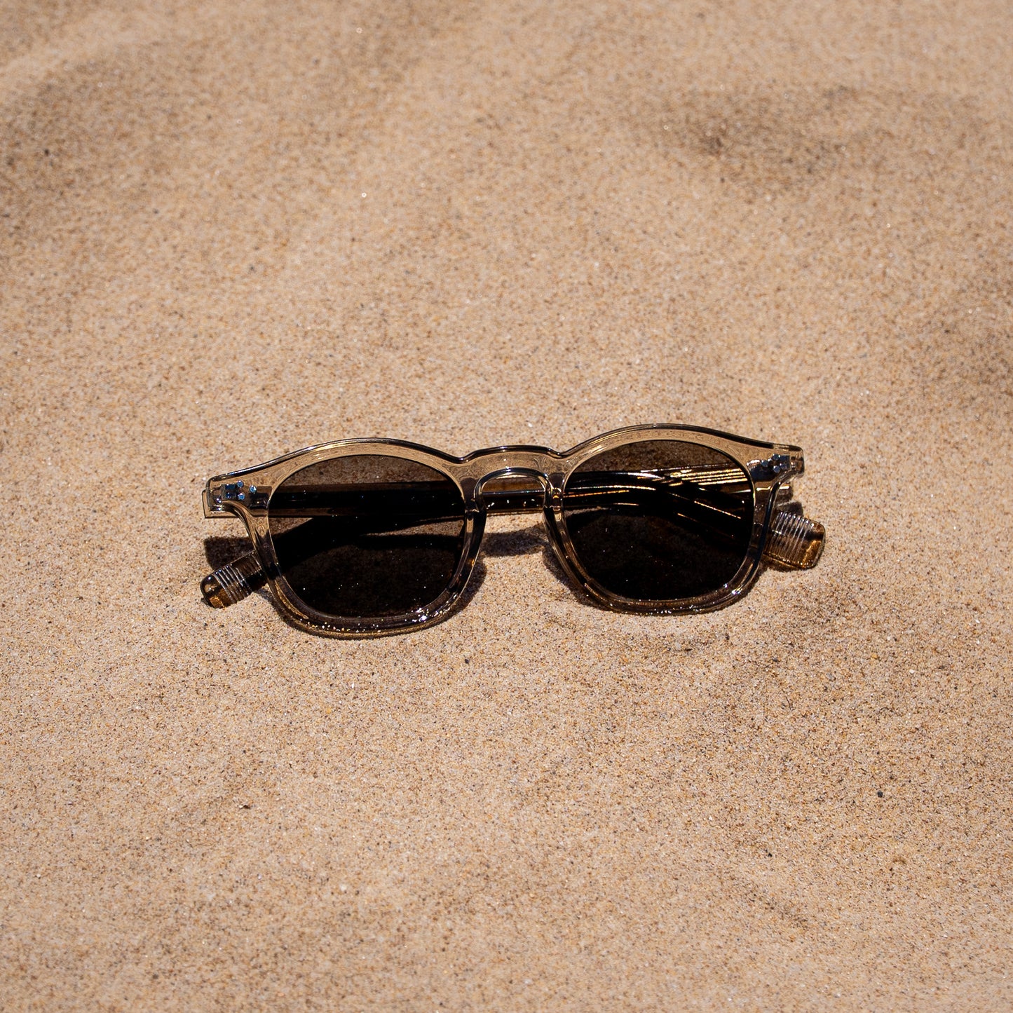 Collin tea zonnebril in het zand | vintage look met grijze glazen