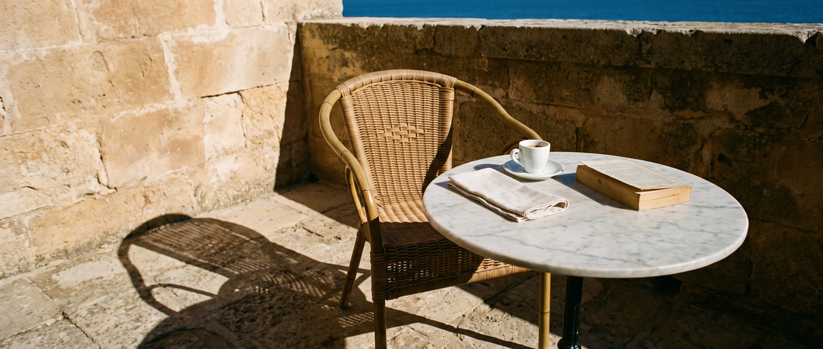 Terras in hard middaglicht met espresso op een marmeren tafel