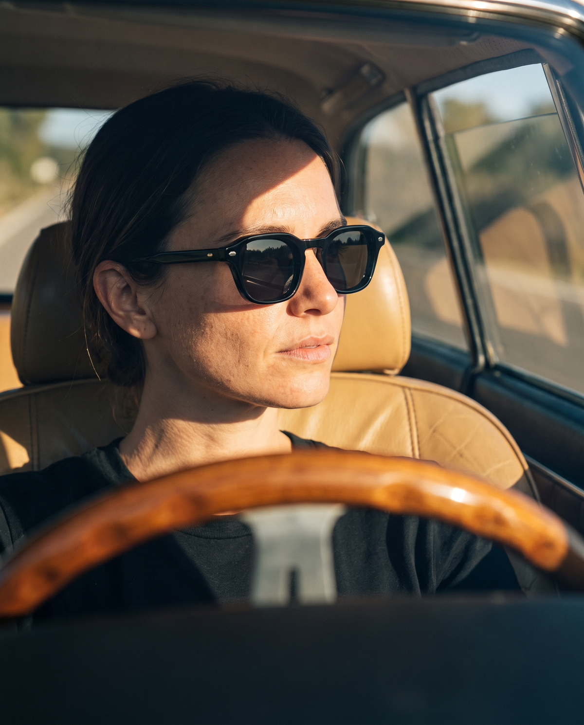 TIBOR sunglasses, black, worn behind the wheel in low afternoon sun
