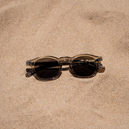 Collin tea zonnebril in het zand | vintage look met grijze glazen