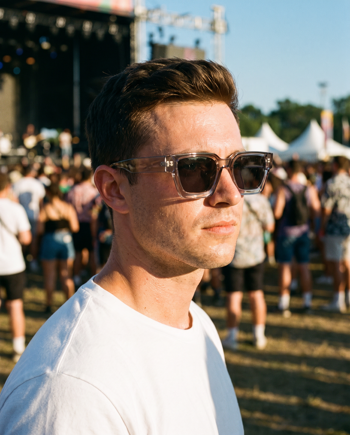 JOHN zonnebril transparant grijs gedragen door een man op een festival