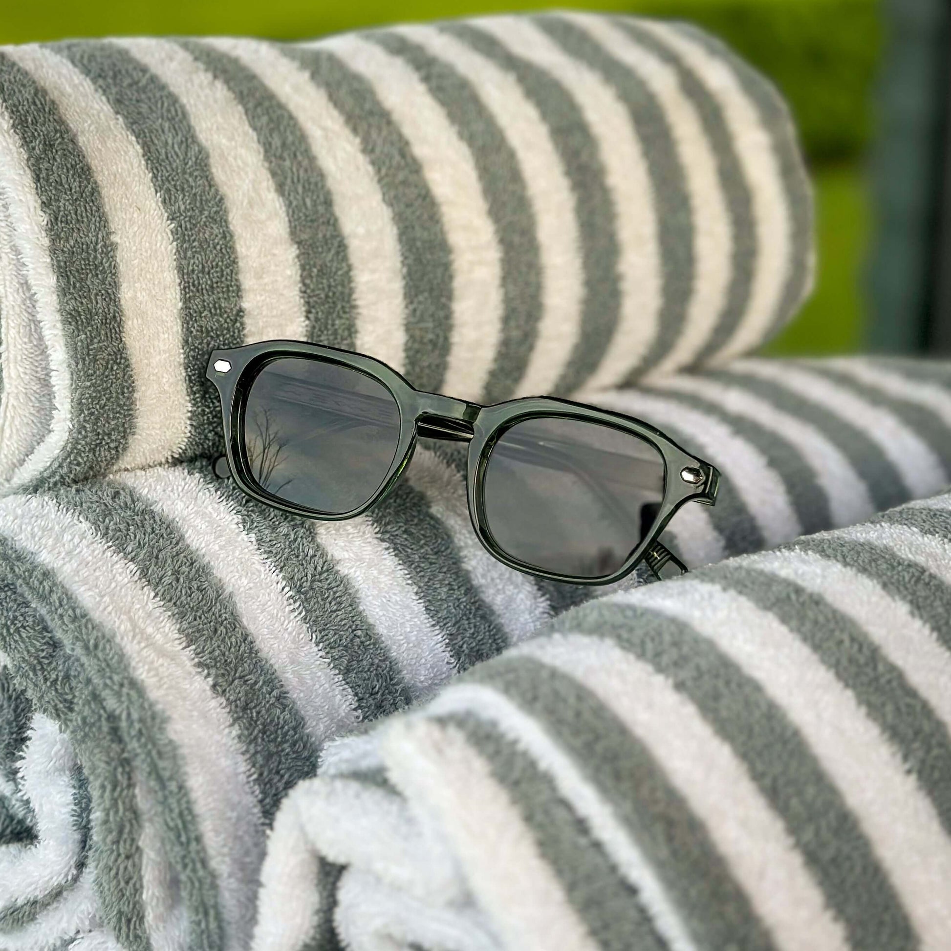 Valentino groene zonnebril op luxe strandhanddoeken | premium summer lifestyle