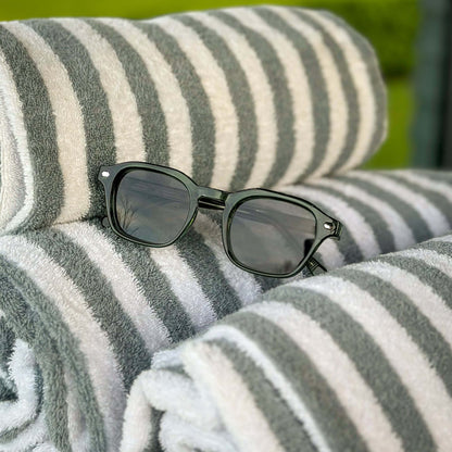 Valentino groene zonnebril op luxe strandhanddoeken | premium summer lifestyle
