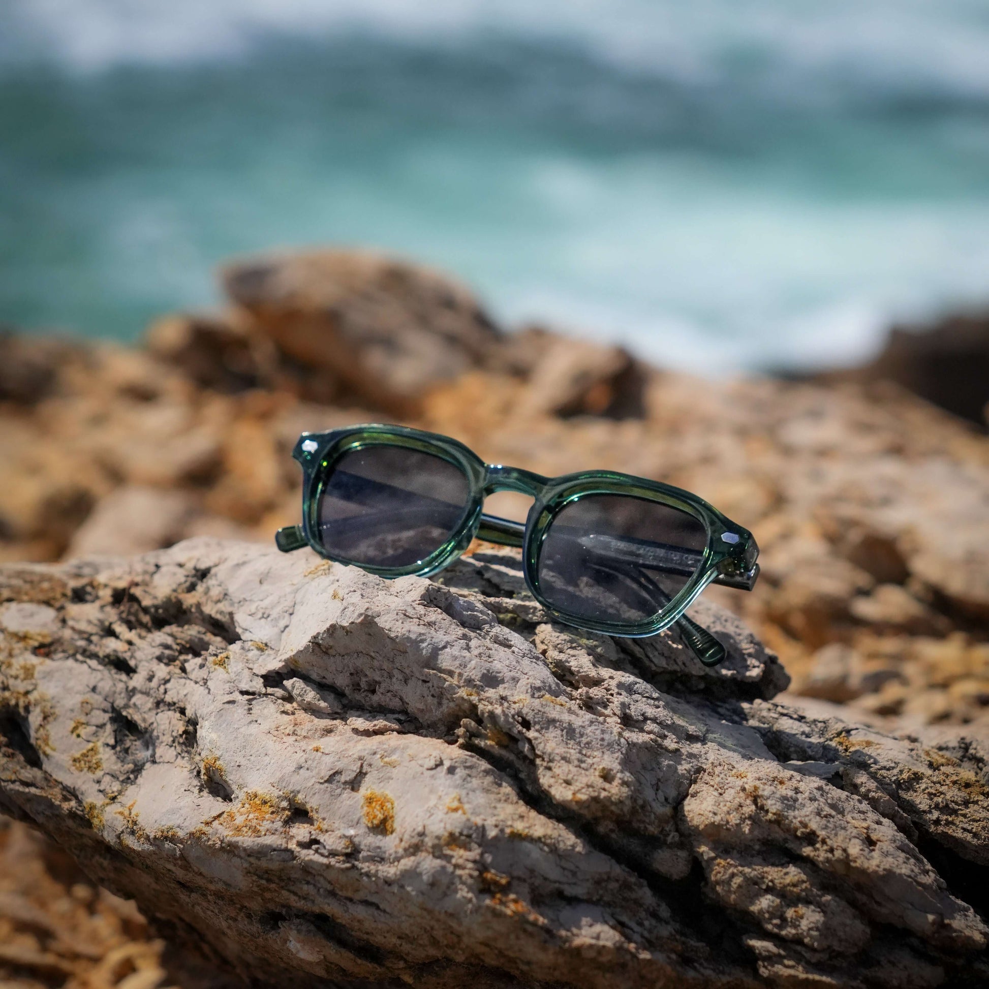 Valentino groene zonnebril op stenen aan zee | zomerse old money look