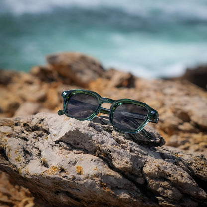 Valentino groene zonnebril op stenen aan zee | zomerse old money look