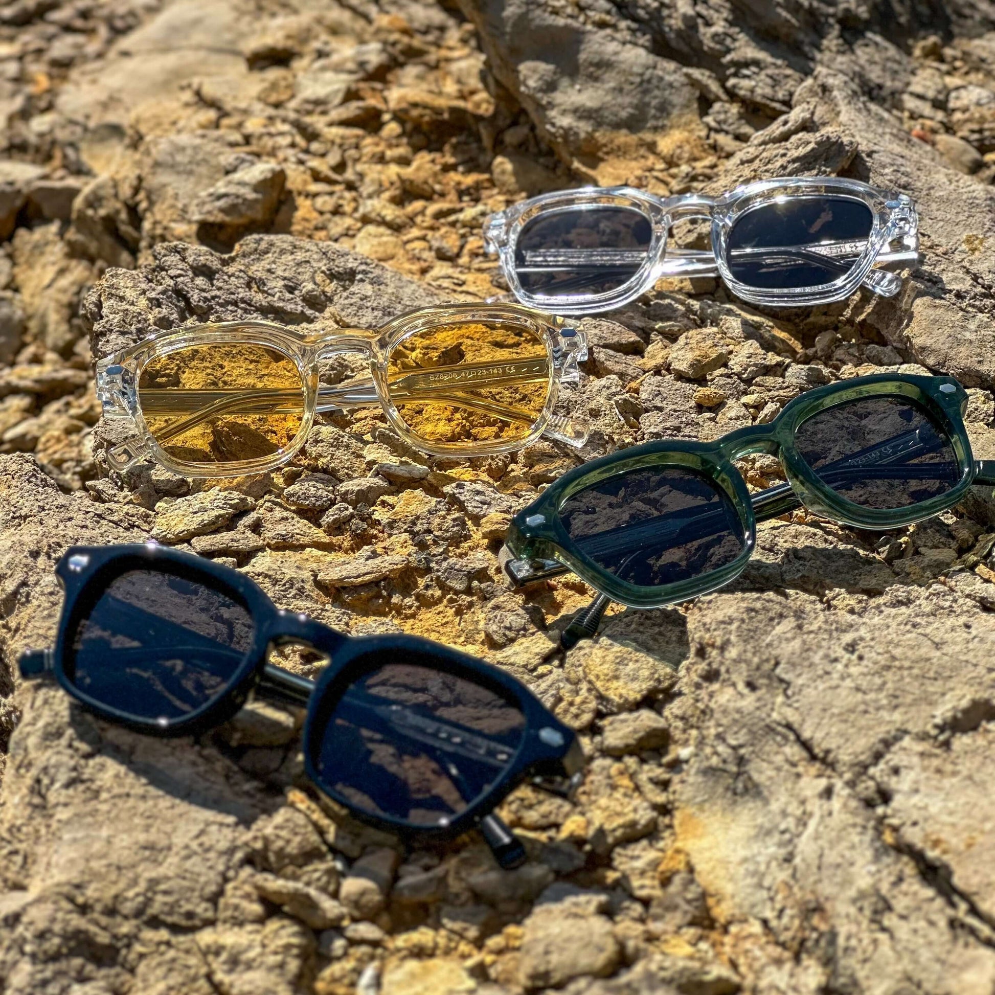 Shadeclub Valentino collectie – zonnebrillen op kuststenen in zomerse sfeer